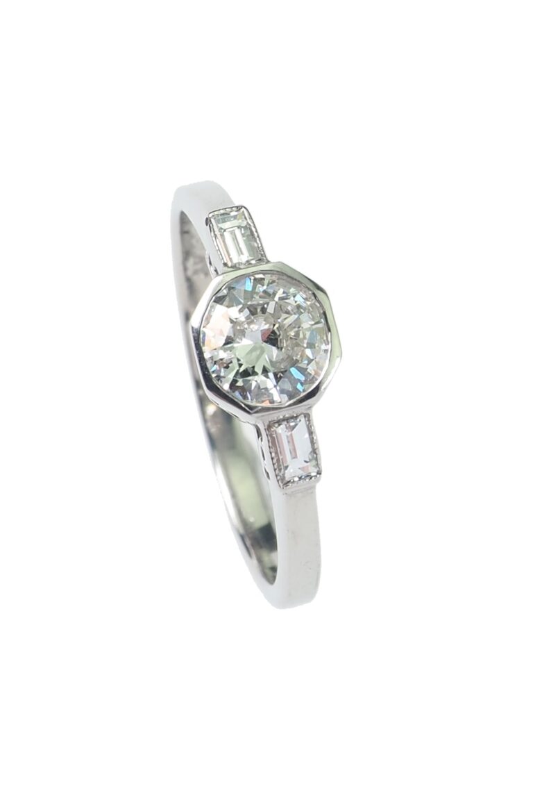 Vintage Verlobungsring mit Diamantsolitaire im Brillantschliff und seitliche Diamanten im Baguetteschliff aus Platin